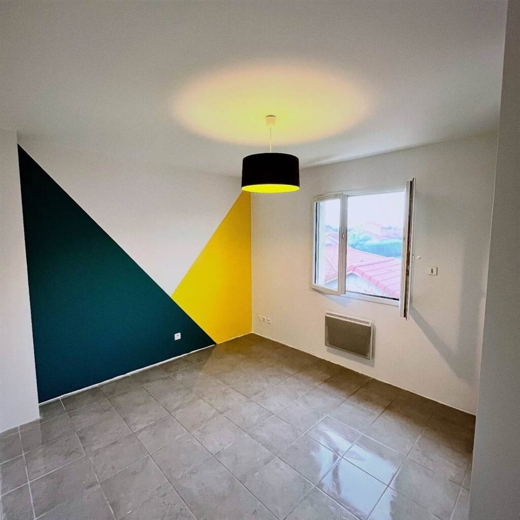 Chambre avec mur graphique bleu et jaune